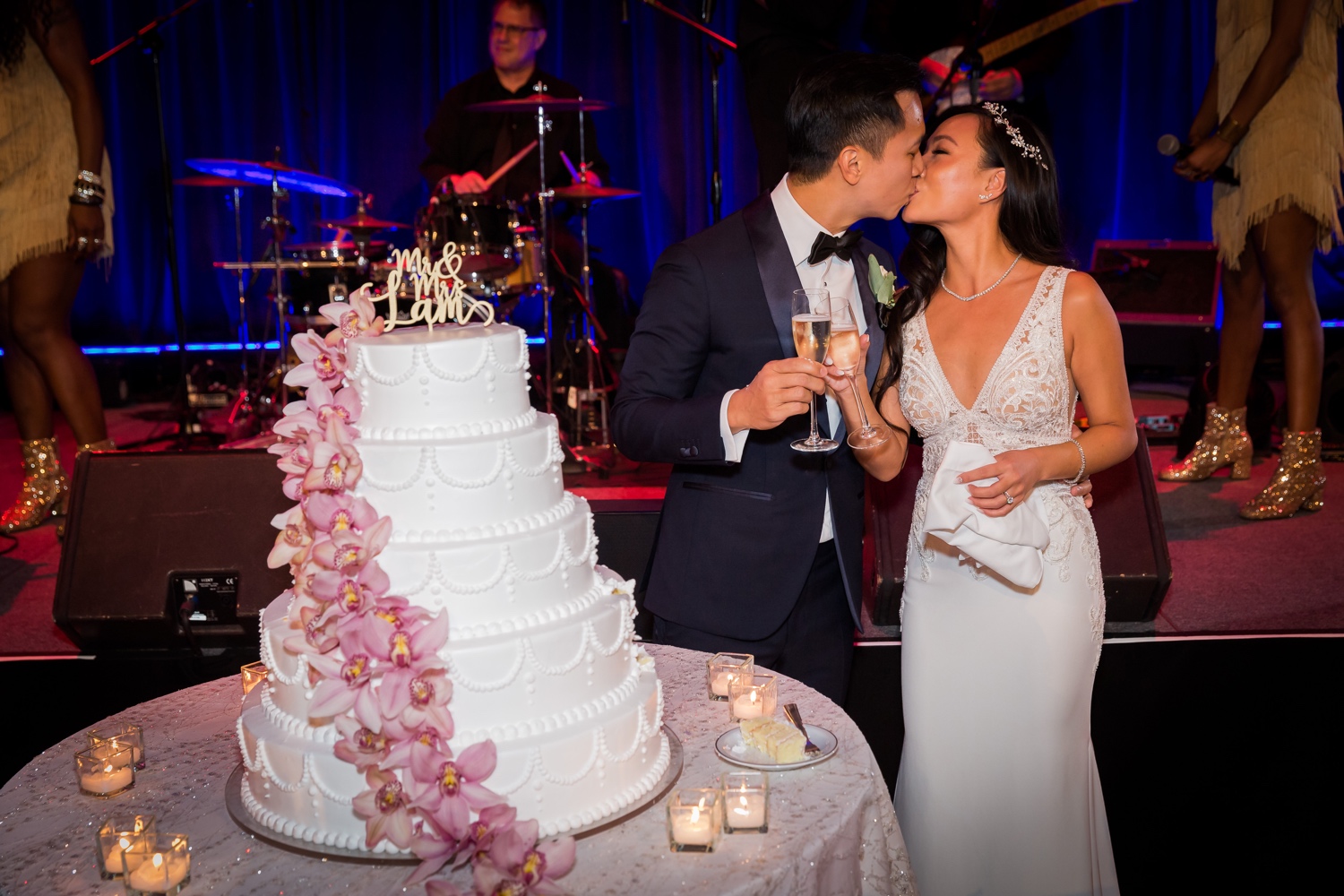 A newly wedded couple kissing next to their wedding cake during a wedding reception at Cipriani Wall Street in New York City.