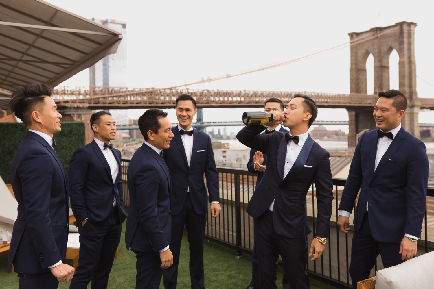 A groom drinking a bottle of champagne as a celebration in Mr. C seaport hotel on a wedding day at Cipriani Wall Street in New York City. 
