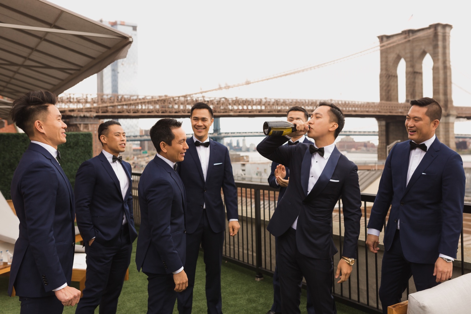 A groom drinking a bottle of champagne as a celebration in Mr. C seaport hotel on a wedding day at Cipriani Wall Street in New York City.