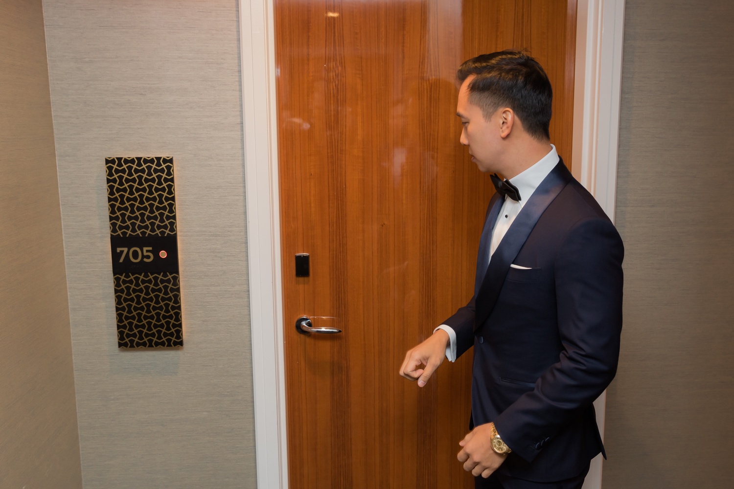 A groom knocking a door to meet his bride in Mr. C Seaport Hotel on a wedding day at Cipriani Wall Street in New York City. 