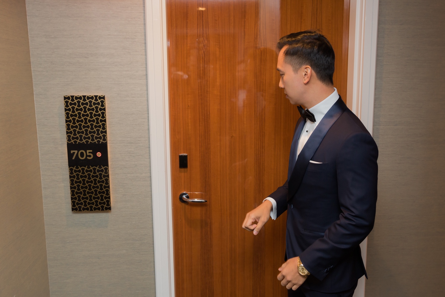 A groom knocking a door to meet his bride in Mr. C Seaport Hotel on a wedding day at Cipriani Wall Street in New York City.