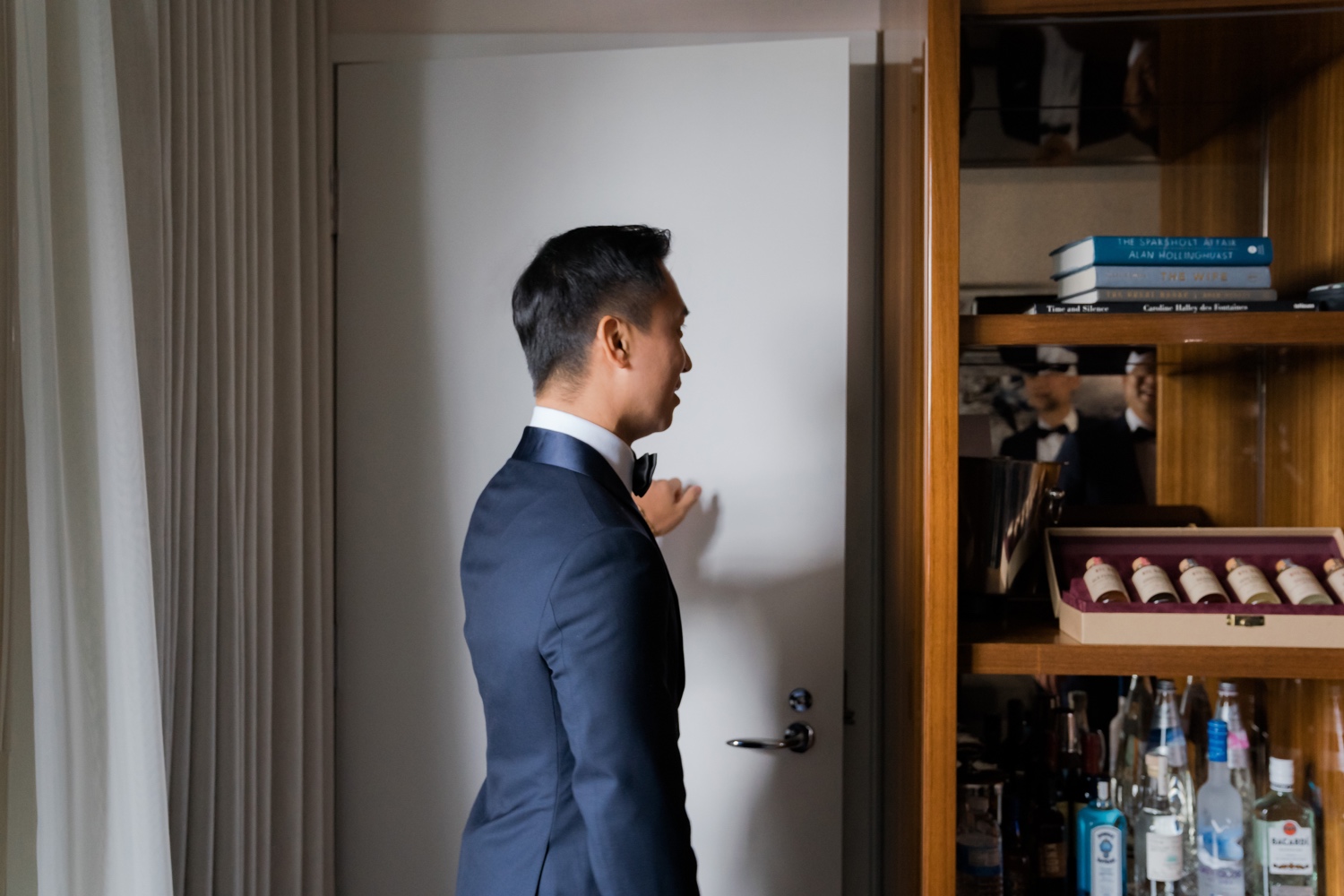 A groom knocking a door to meet his bride in a chinese dress in Mr. C Seaport Hotel on a wedding day at Cipriani Wall Street in New York City. 