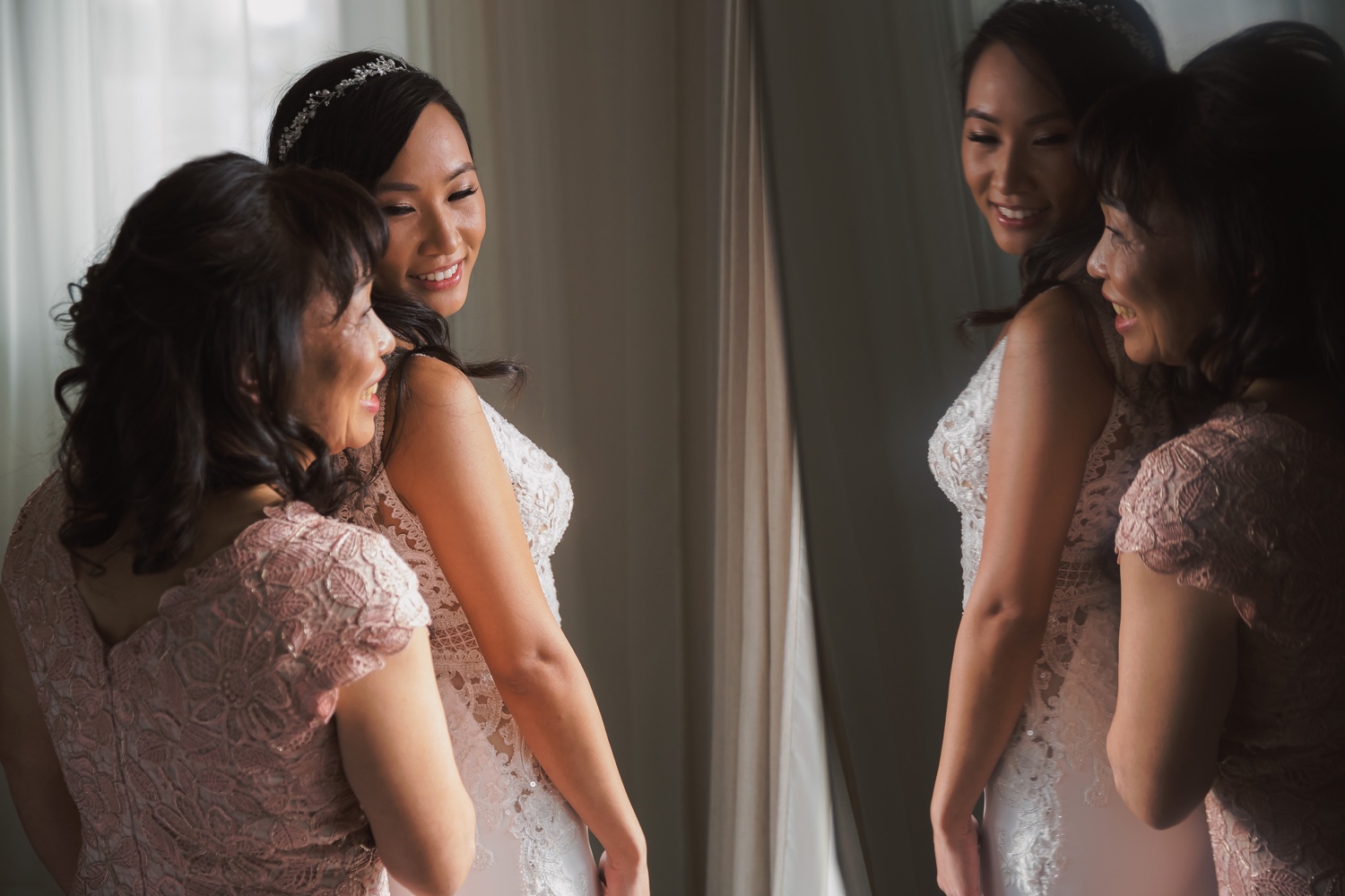 A portrait of a bride and her mother getting ready for a wedding ceremony at Cipriani Wall Street in New York City. Wedding Dress by Pronovias.