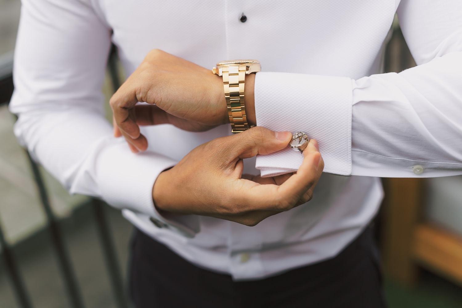 A groom wearing his cufflinks in a Mr. C Seaport Hotel on a wedding day at Cipriani Wall Street in New York City. 