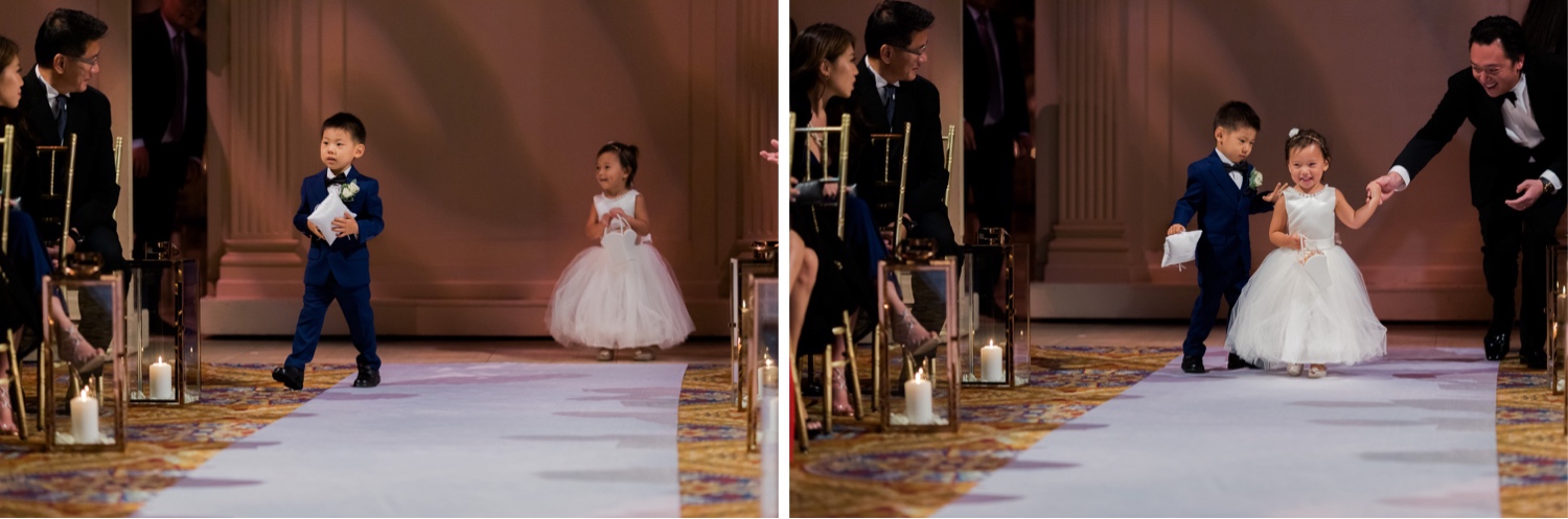 A wedding bearer and a flower girl walking in an aisle during a wedding ceremony at Cipriani Wall Street in New York City. 