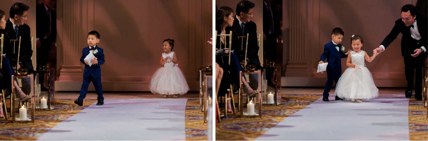 A wedding bearer and a flower girl walking in an aisle during a wedding ceremony at Cipriani Wall Street in New York City.