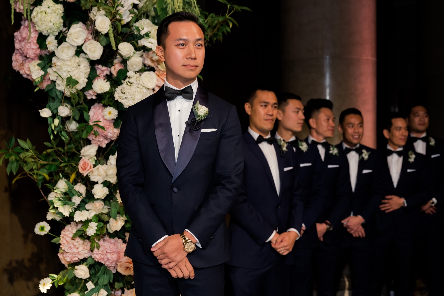 A groom looking at his bride walking in an aisle during a wedding ceremony at Cipriani Wall Street in New York City. 