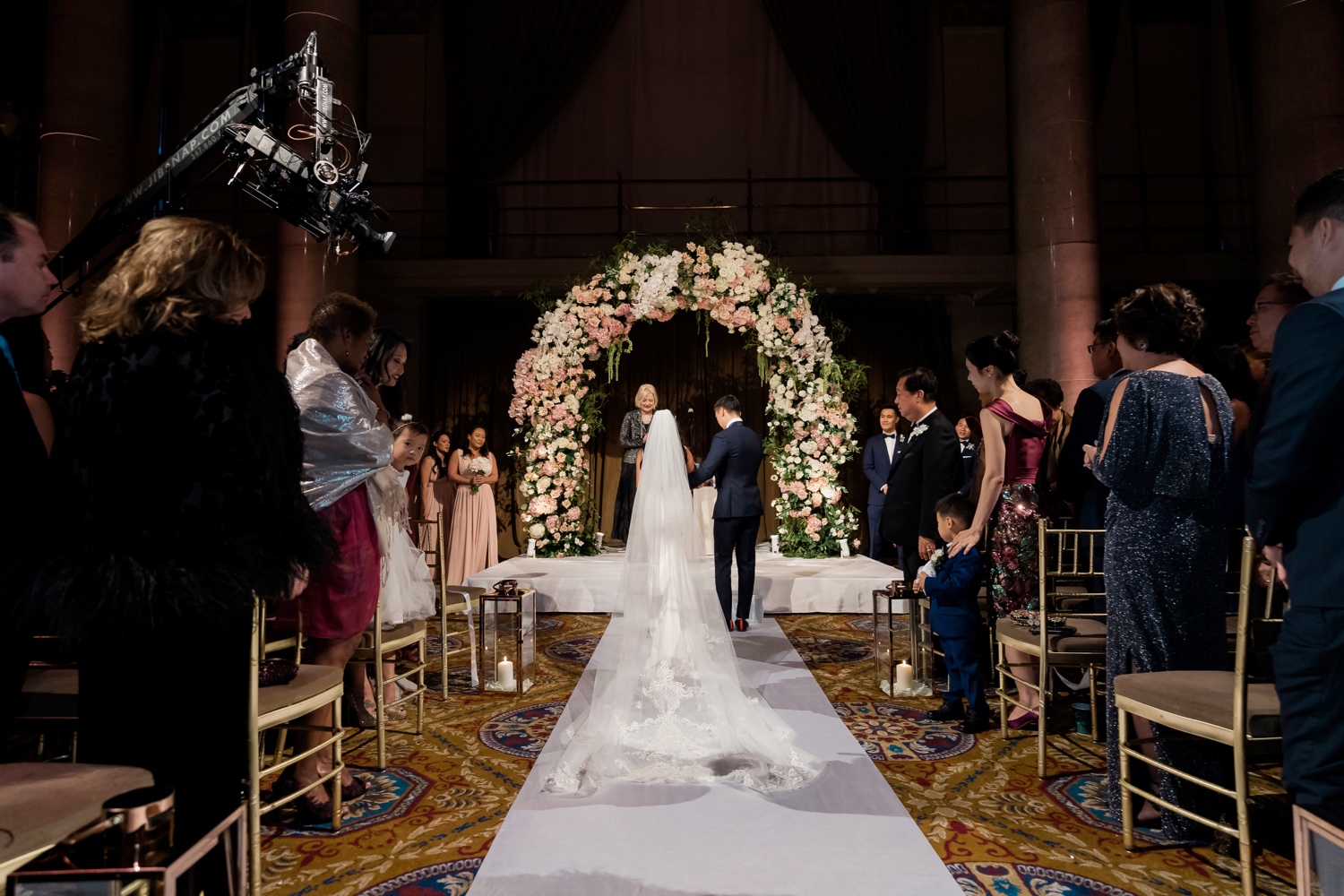 A bride and a groom entering their wedding ceremony at Cipriani Wall Street in New York City. 