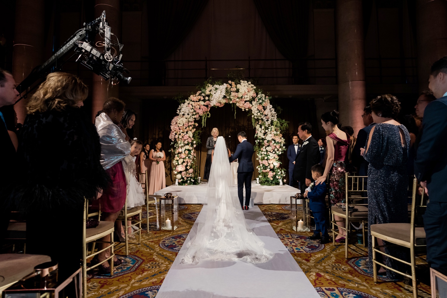 A bride and a groom entering their wedding ceremony at Cipriani Wall Street in New York City.