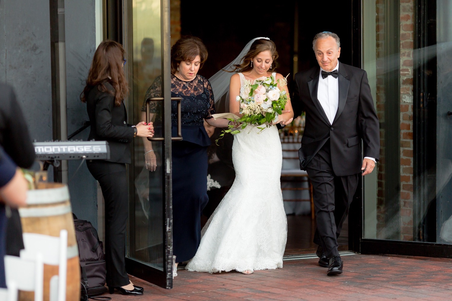A bride and her parents entering the bride's ceremony at Liberty Warehouse, Brooklyn New York. 