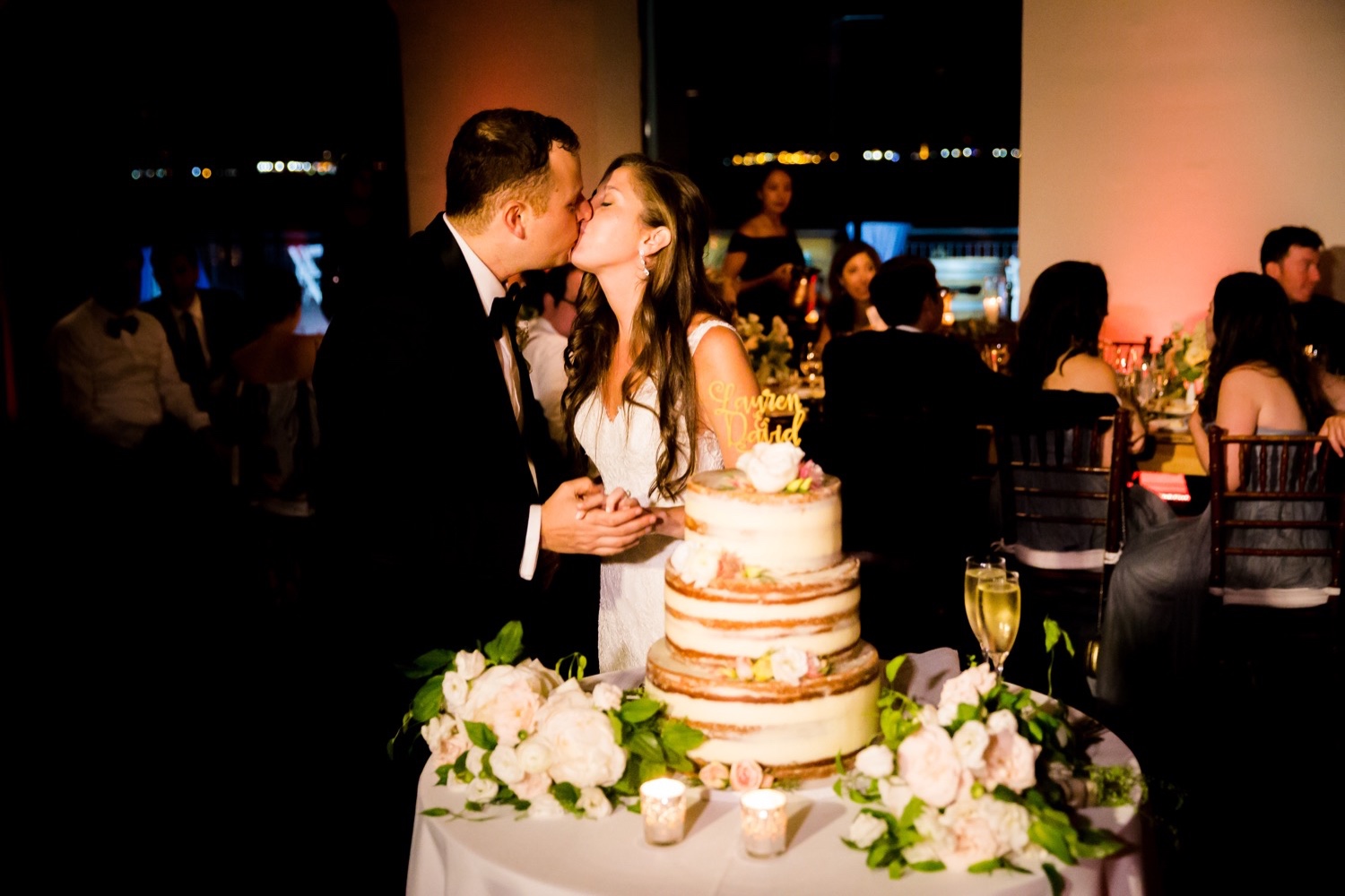 A newly wedded couple cutting their wedding cake during a wedding reception at Liberty Warehouse, Brooklyn New York. 