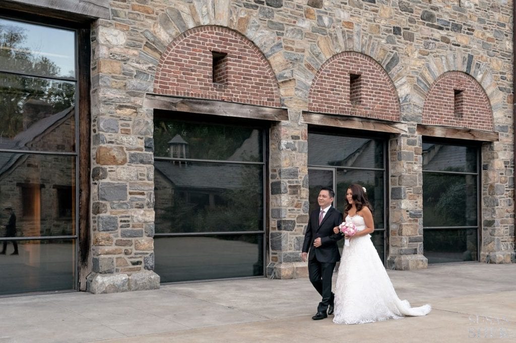 bride and her uncle walking down wedding ceremony at blue hill stone barns