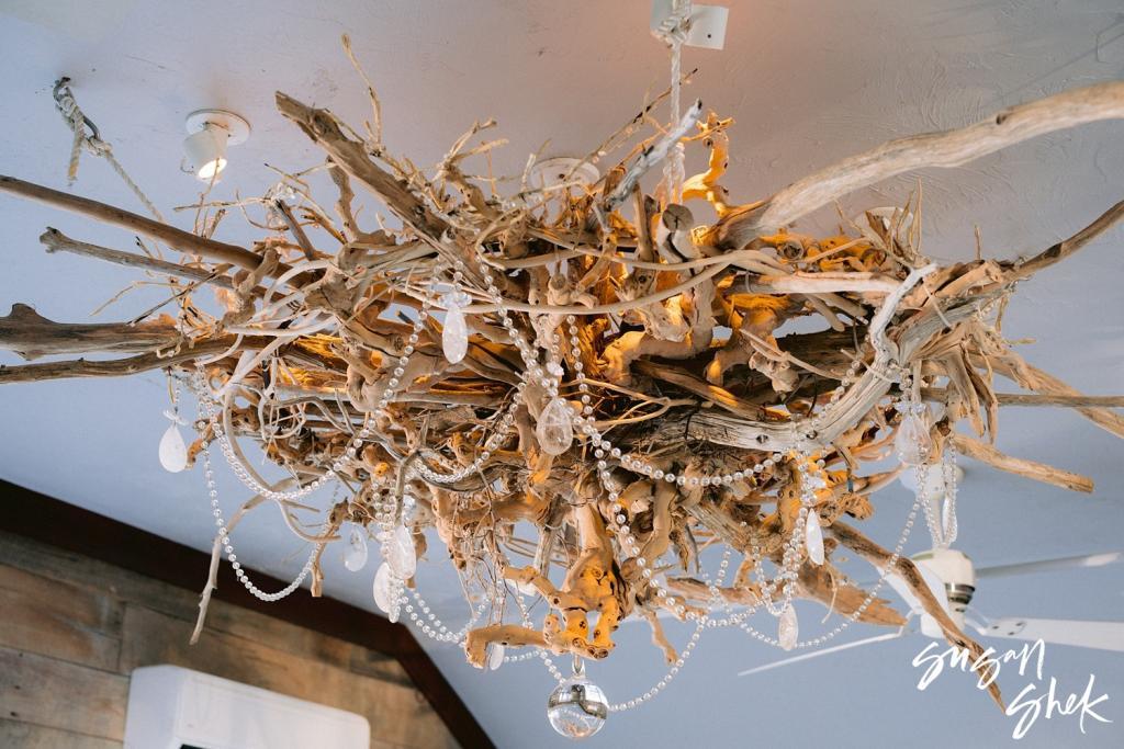 Driftwood chandelier hung with strands of pearls and shells
