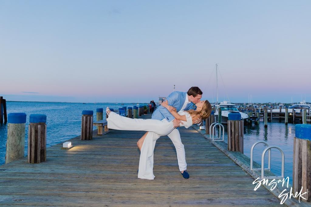Couple sharing a dip kiss on the pier at dusk