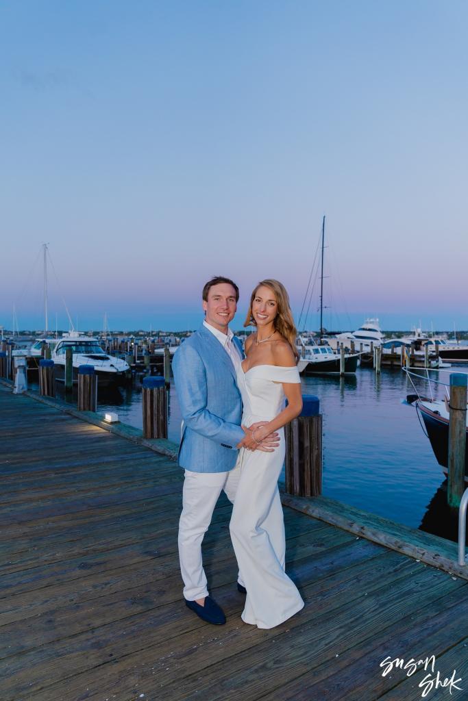 Couple posing together on the dock at twilight