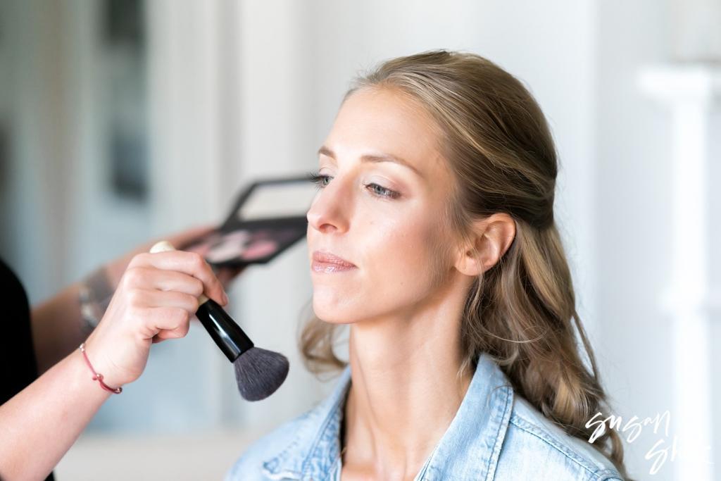 Bride having her makeup applied on the wedding morning