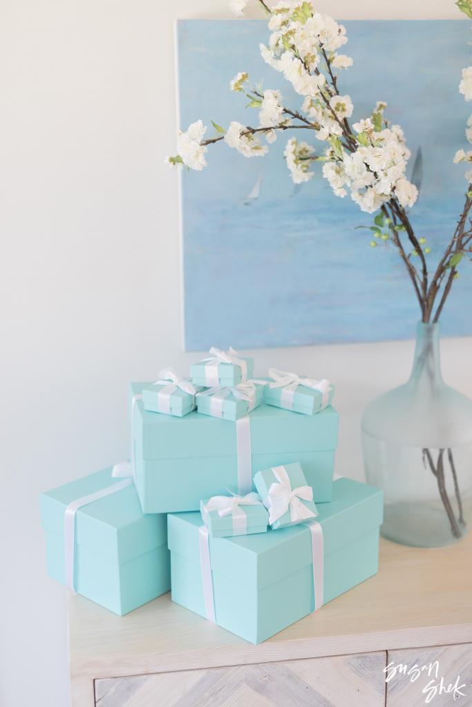 Robin's egg blue gift boxes beside a vase of flowering branches