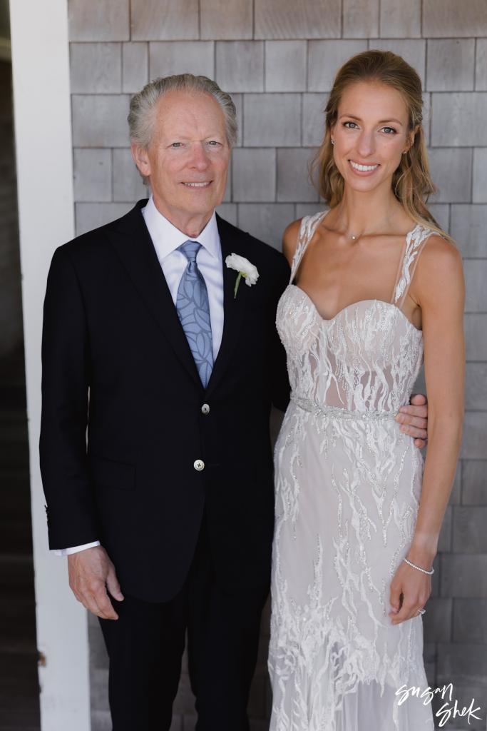 Bride with a family member in a navy blazer against cedar shingles
