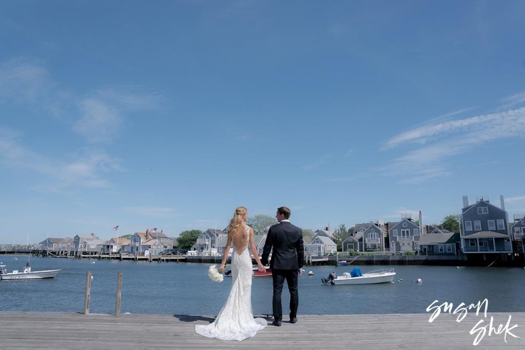 Bride and groom looking out over Nantucket harbor from the dock