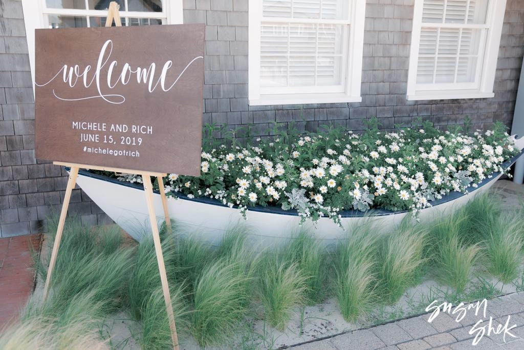 Welcome sign for Michele and Rich, June 15, 2019, beside a white rowboat filled with flowers