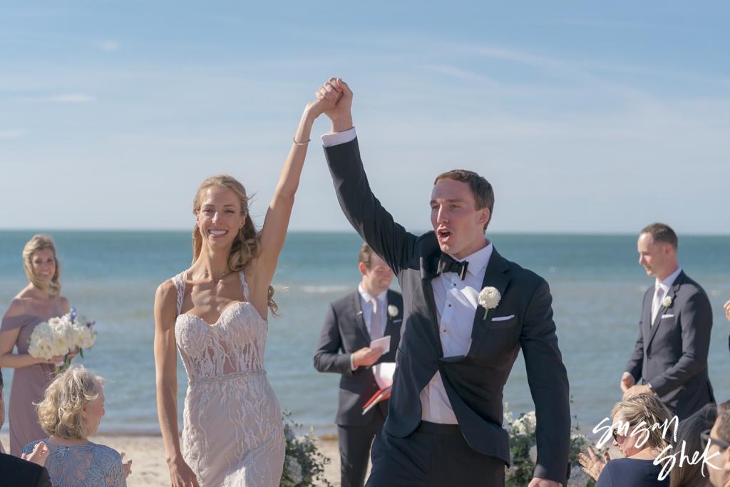 Bride and groom raising their joined hands after being declared married