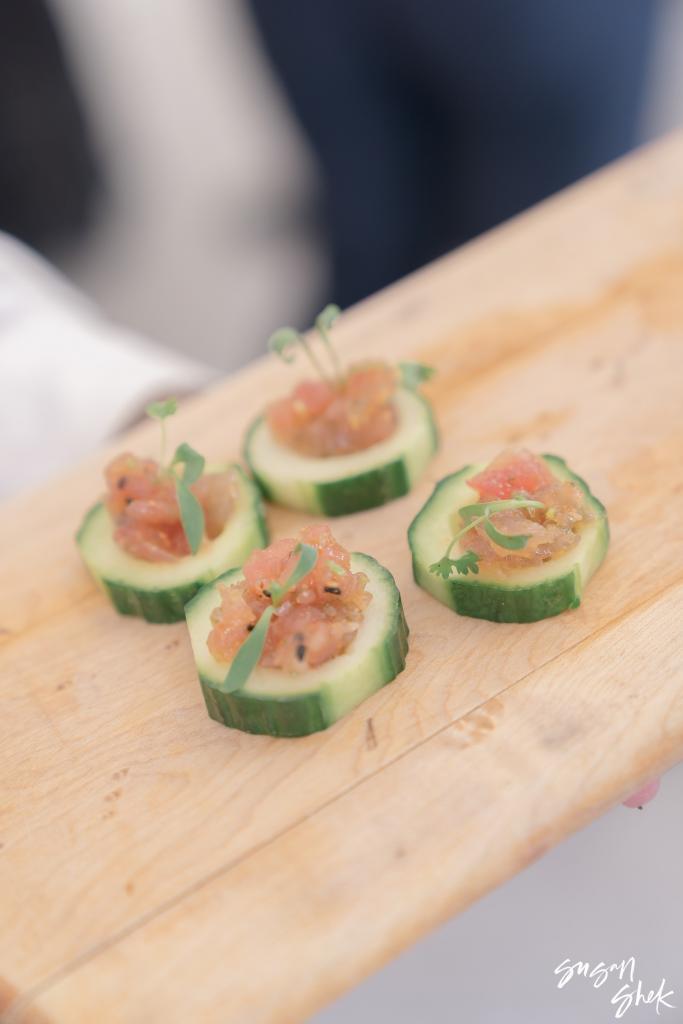 Cucumber rounds topped with tartare on a wooden board