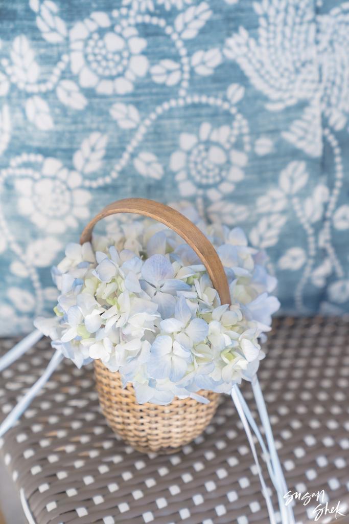 Woven basket of pale blue hydrangeas for the flower girl