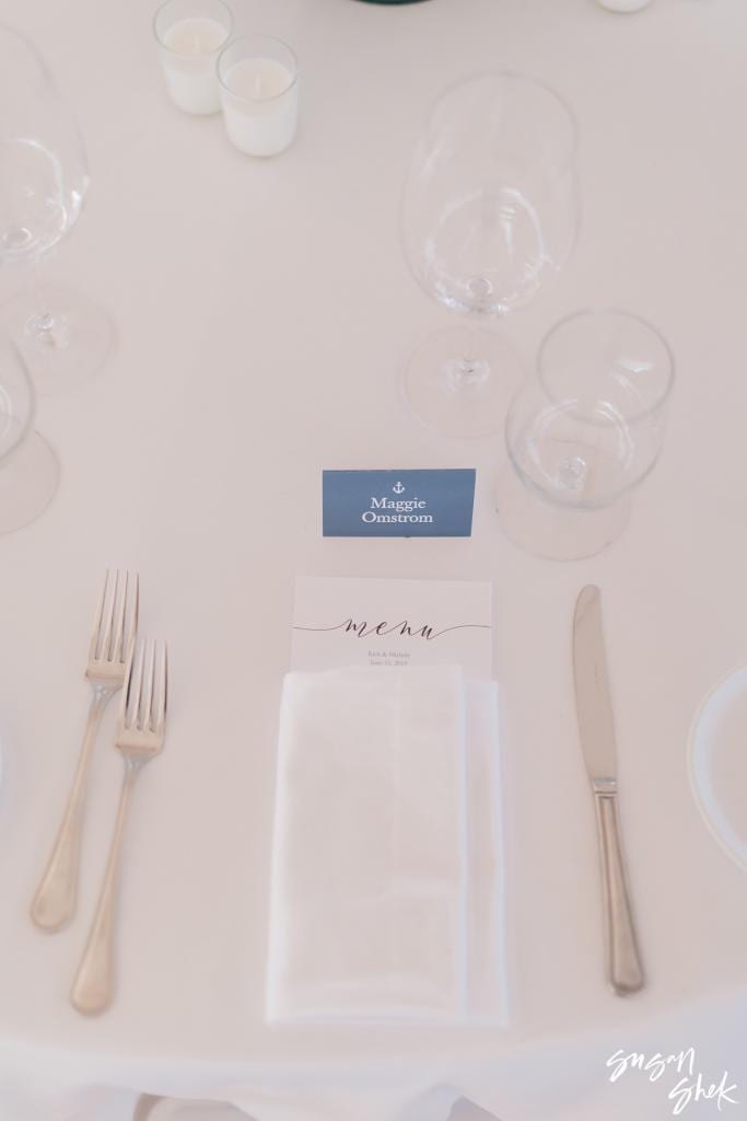 Place setting with a calligraphy menu and a navy name card