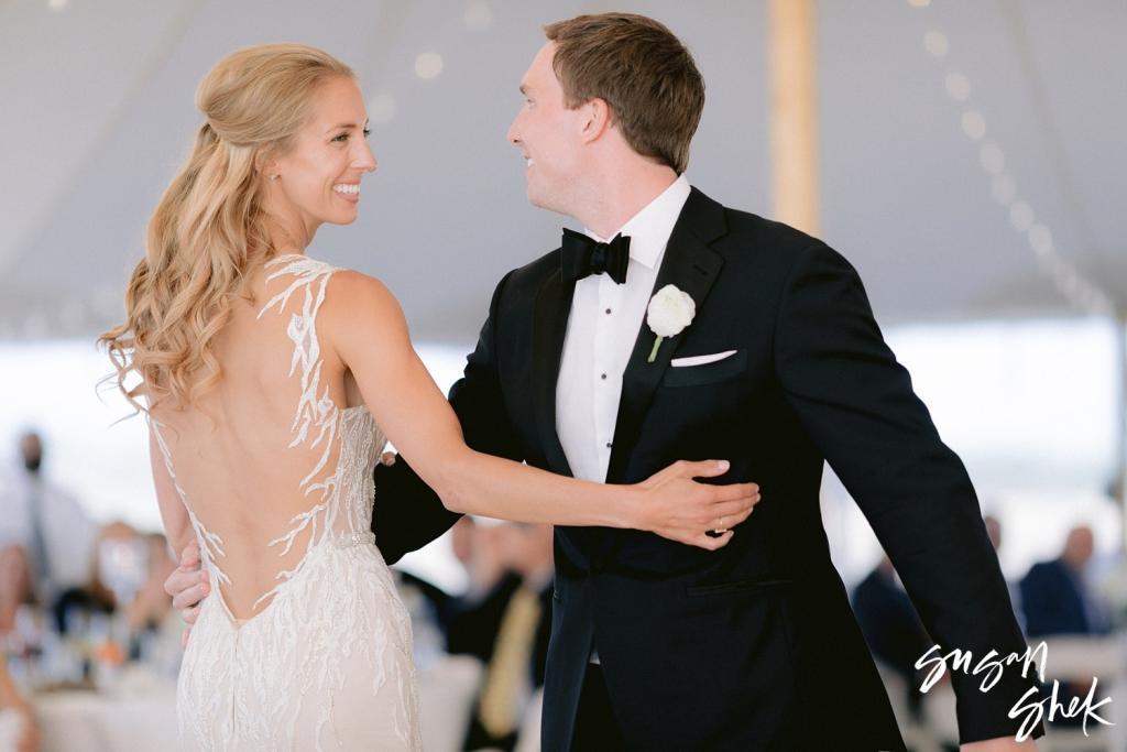 Bride and groom smiling at each other mid dance