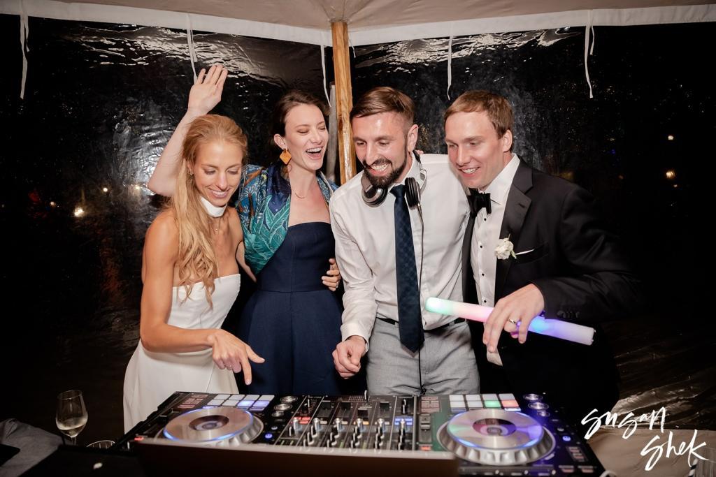 Bride and groom at the DJ booth with friends late in the night