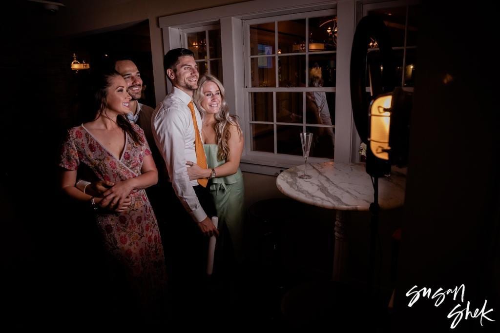 Guests posing for a photo by the windows late in the evening
