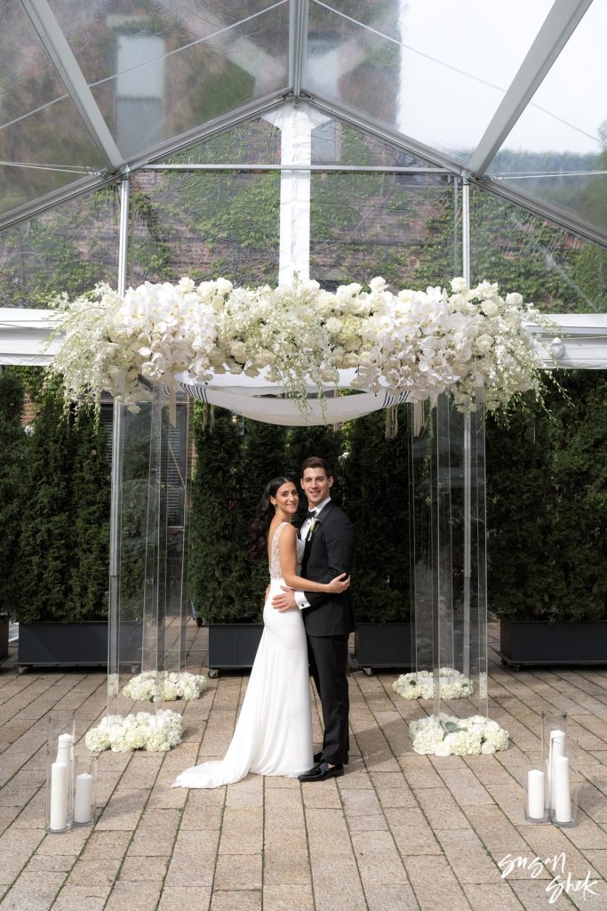 Couple posing for portraits under the chuppah