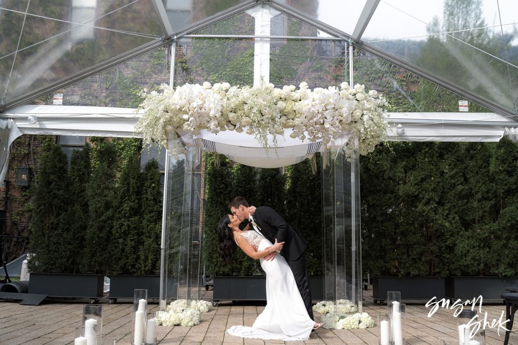 couple kissing under the chuppah at the foundry LIC