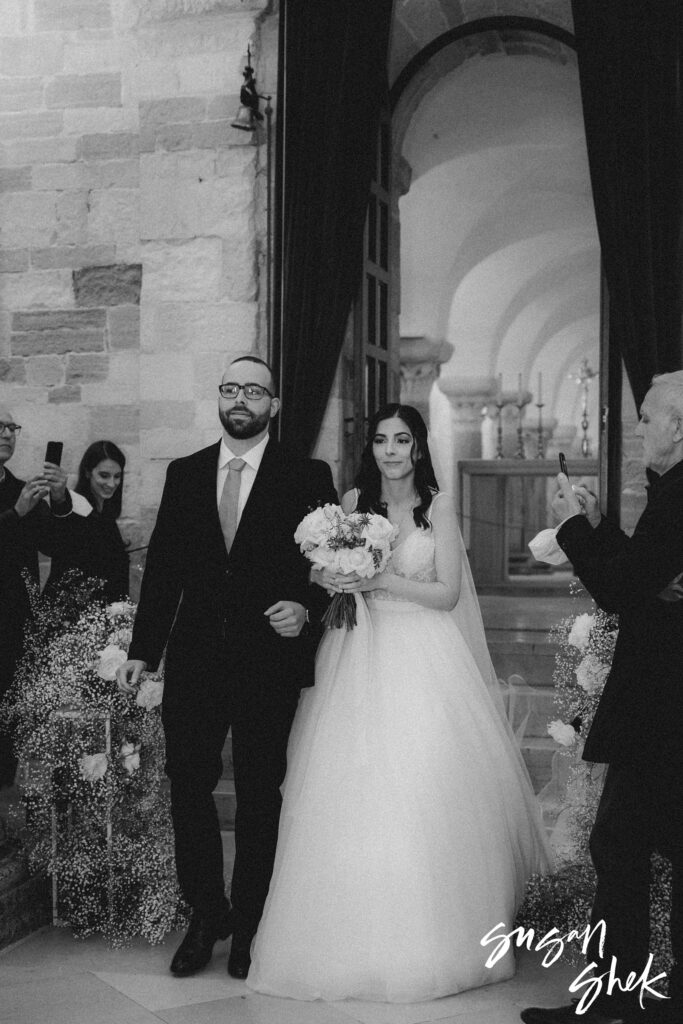 bride walking down aisle with brother at trani cathedral in puglia italy