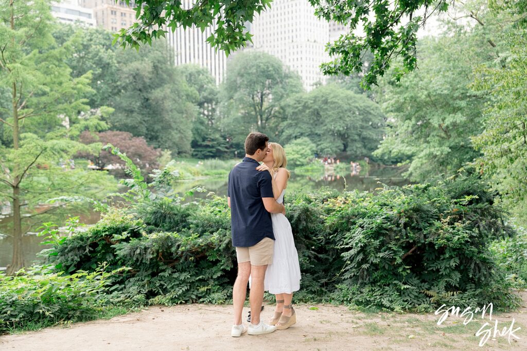 kissing in central park by the pond after the surprise proposal