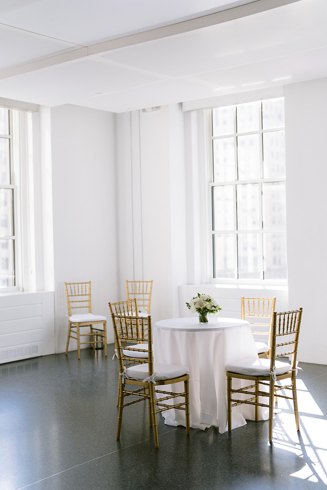 620 Loft and Garden reception room with two long tables styled with white florals and candles