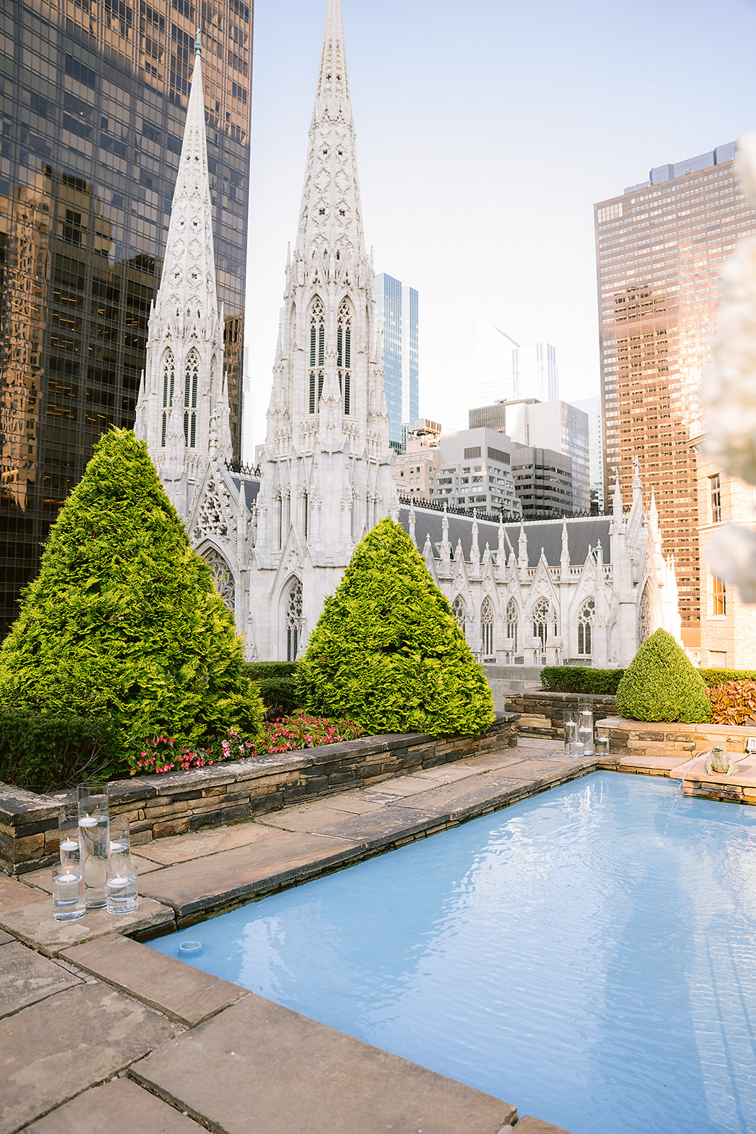 by the reflecting pool at 620 Loft and Garden with St. Patrick’s Cathedral behind them