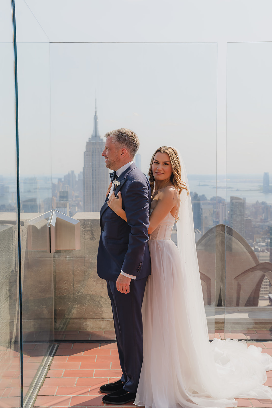 Wedding photo on Top of the Rock with flowing veil and Empire State Building view