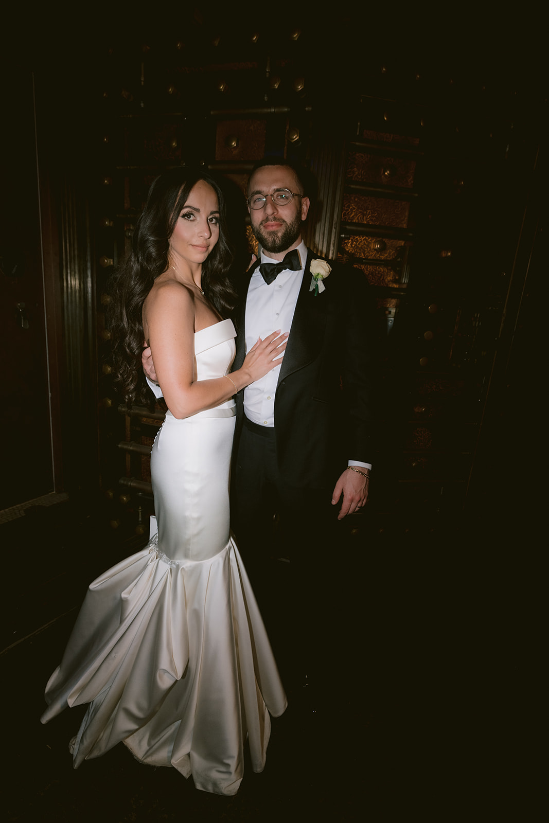 Elegant wedding portrait of the couple inside Capitale’s historic bank vault with dramatic lighting.