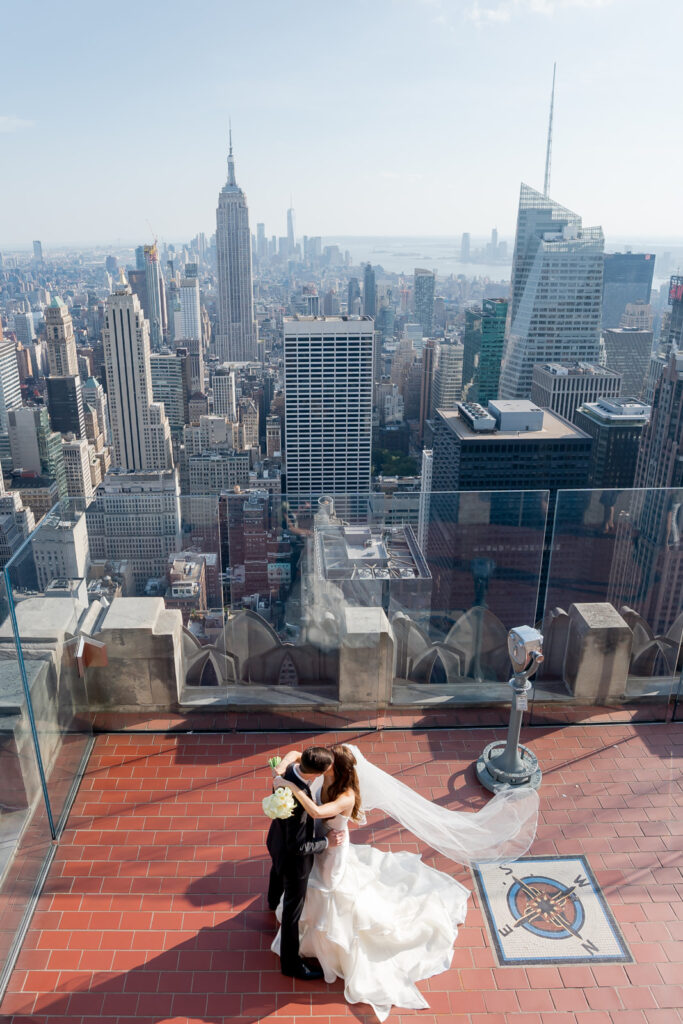 Bride and groom sharing a kiss on the rooftop during an elegant NYC wedding