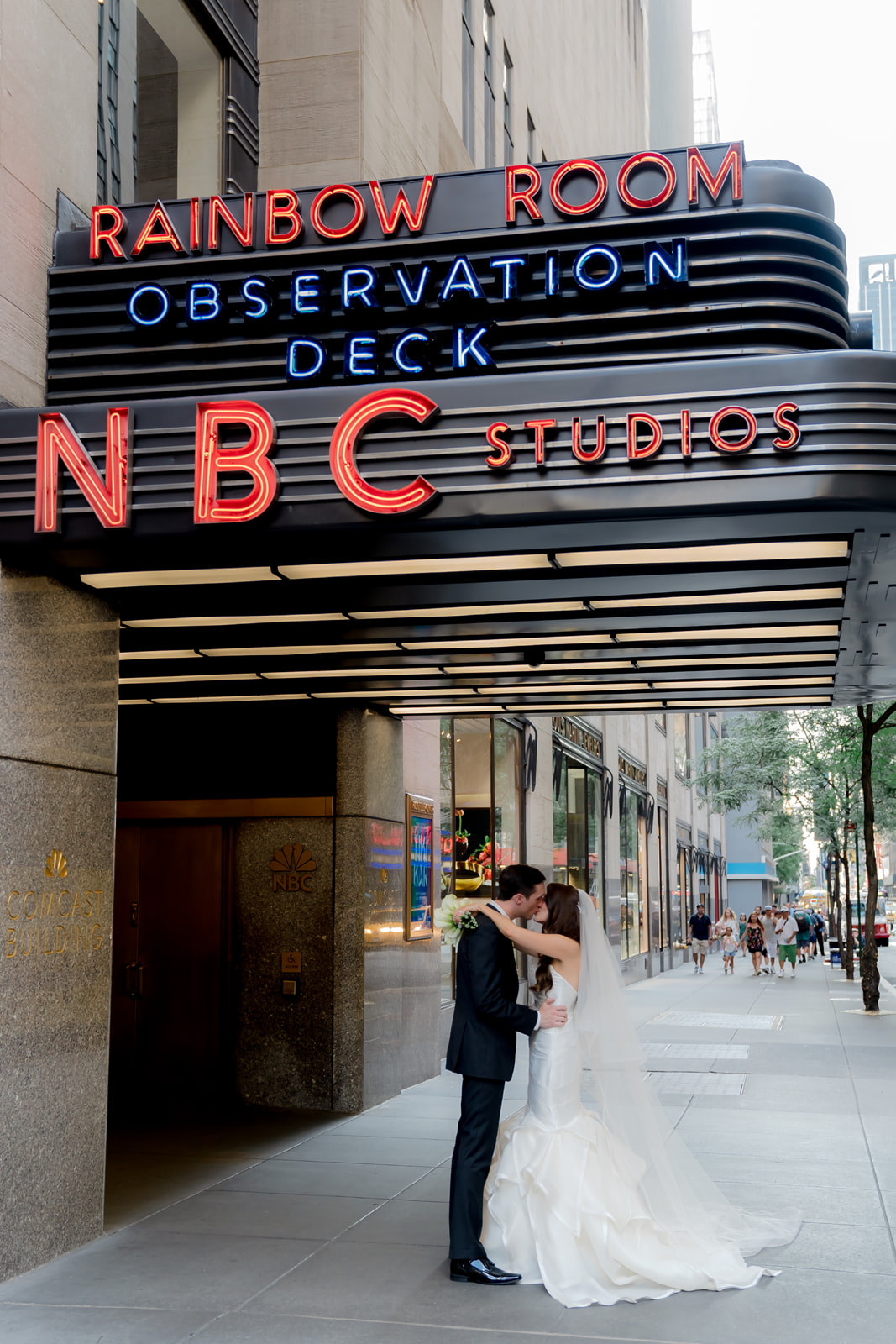 A bride and groom sharing a kiss under the famous rainbow room in NYC