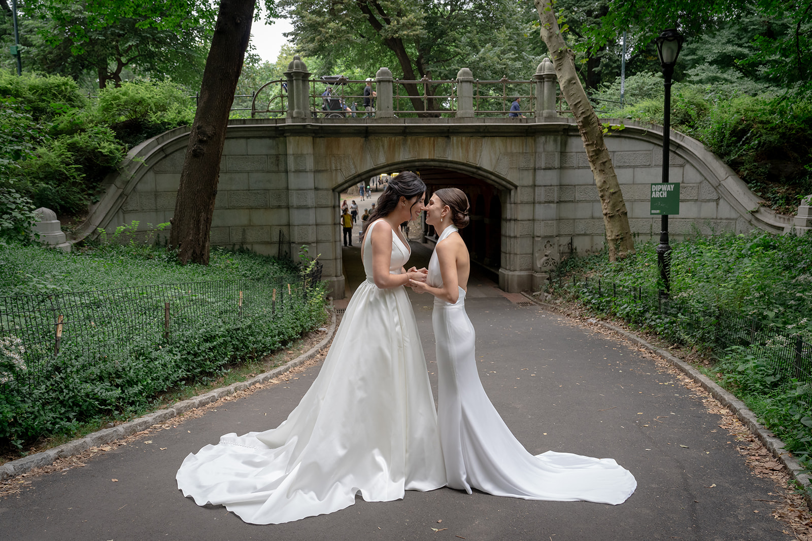 Two brides embracing each other for their first look photos in central park 