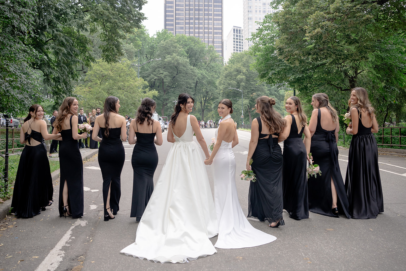 A group wedding photo with two brides in the center surrounded by their bridesmaids  