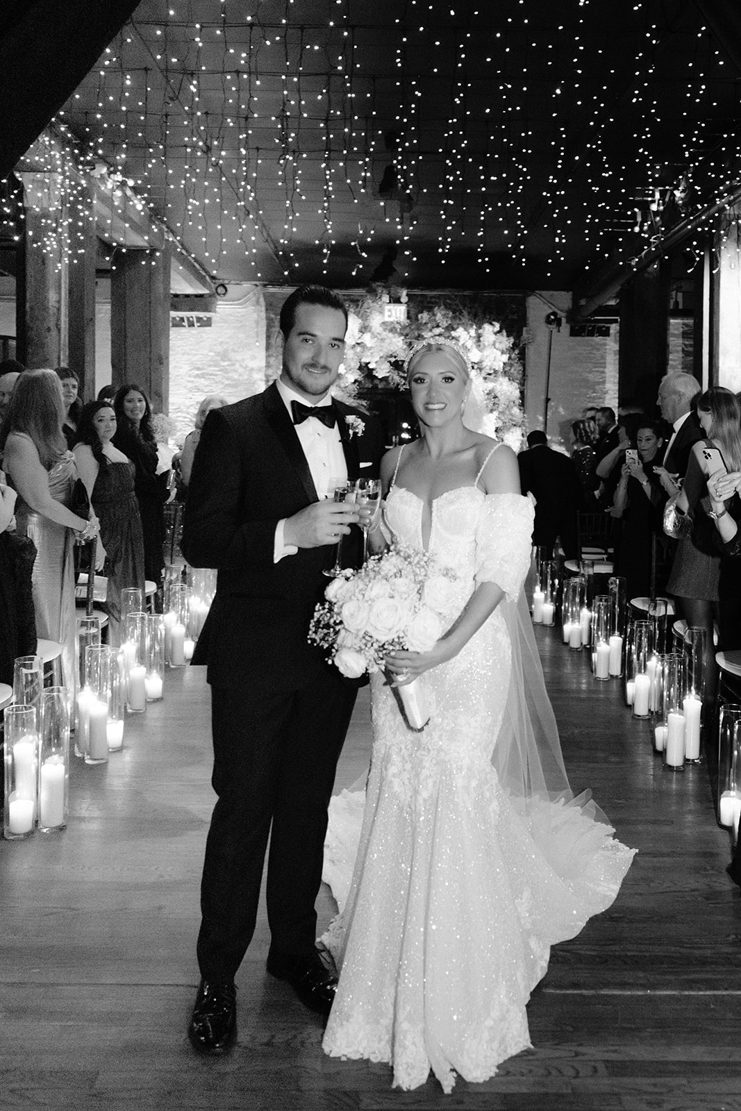 classic black and white photo of groom and bride walking down the aisle 
