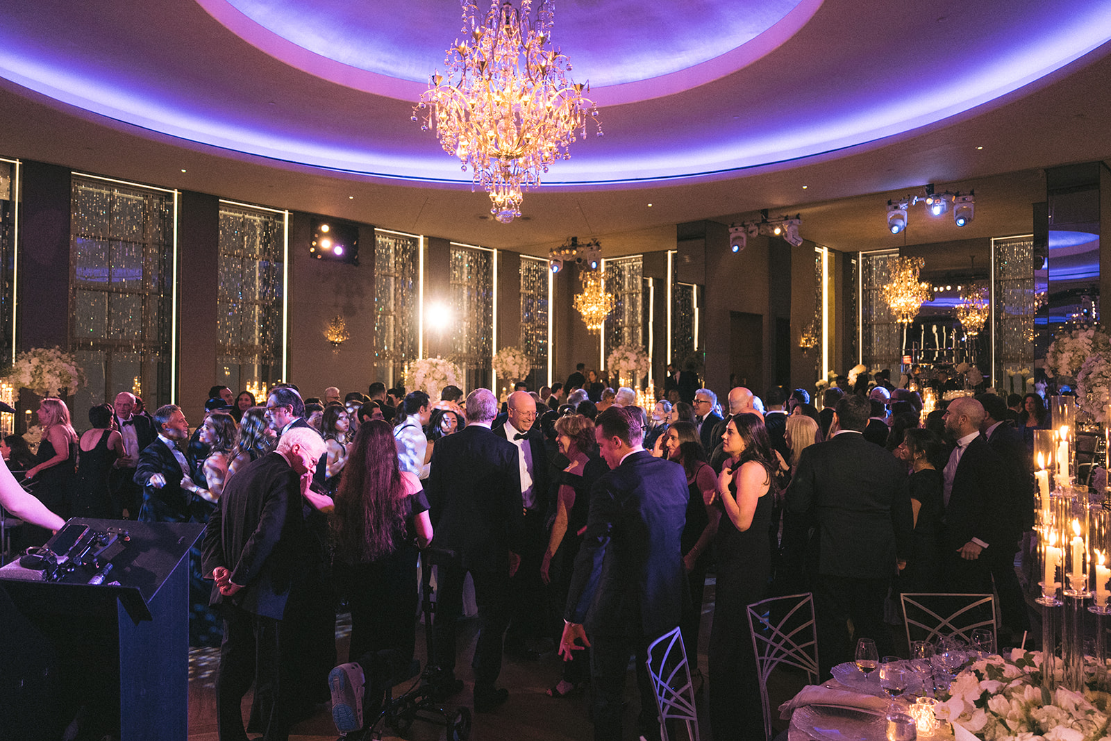Packed dance floor under grand chandelier during a lively Rainbow Room NYC wedding celebration.