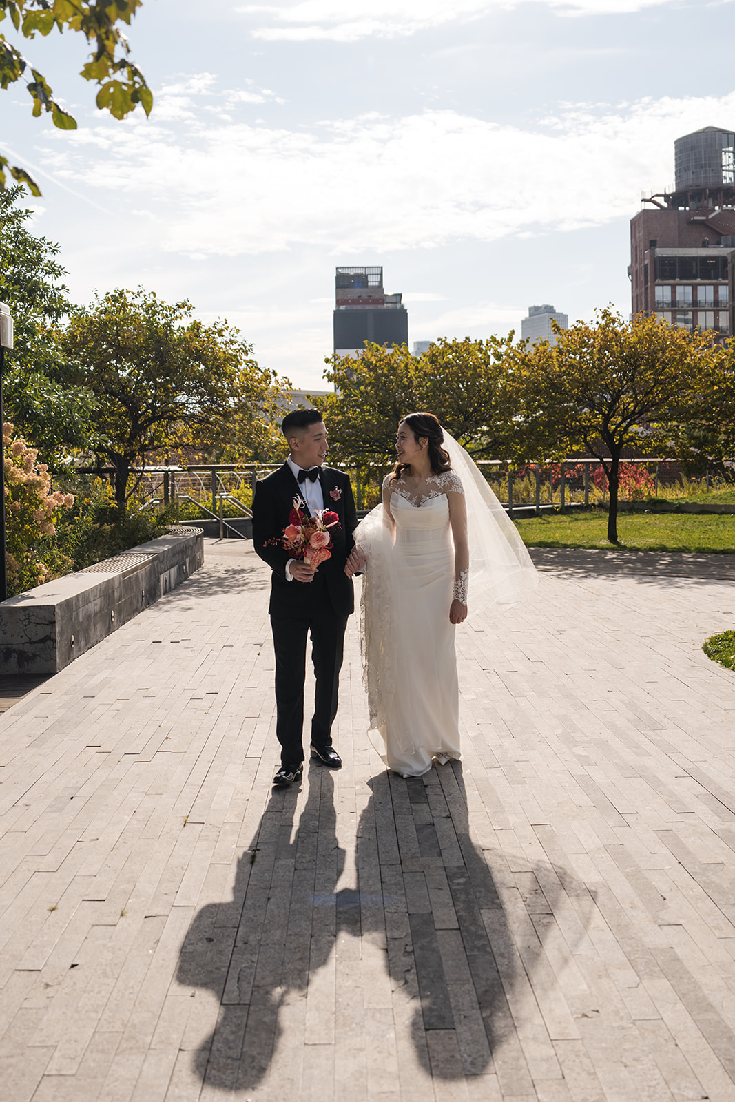 a bride and groom holding hands, gazing at each other for their NYc wedding portraits